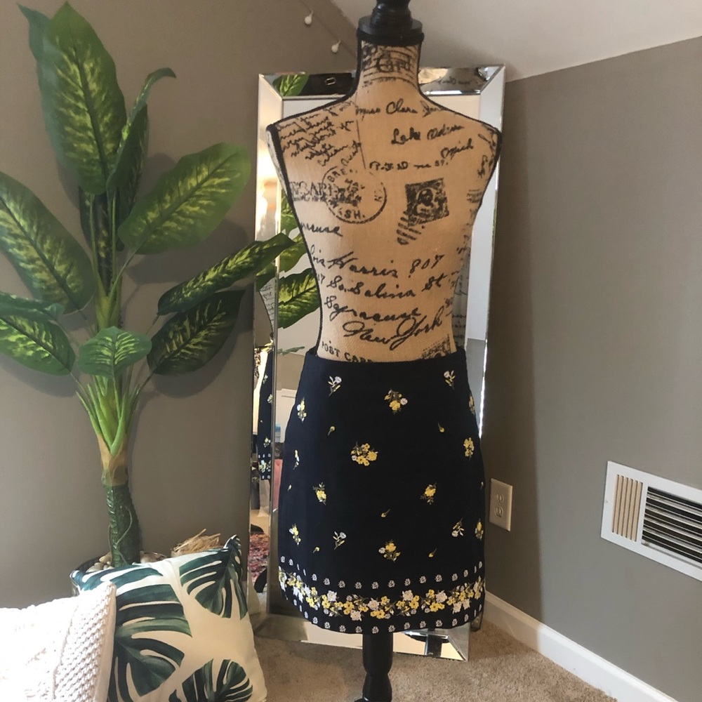 Navy blue skirt with embroidered flowers.